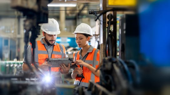Engineers observing the Robotics arm welding units operating at factory.