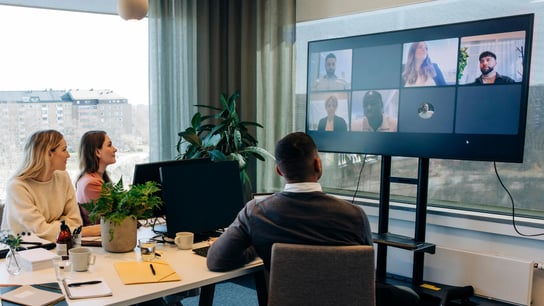 group meeting on tv screen in office