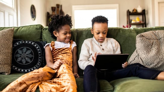 Telesoft Technologies made standards key to strategy - Brother and sister watching digital tablet on sofa at home