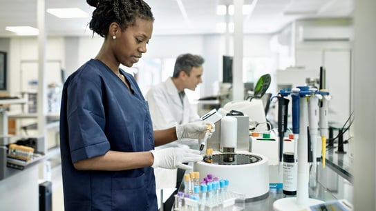 Pathology technician in blue scrubs in laboratory test