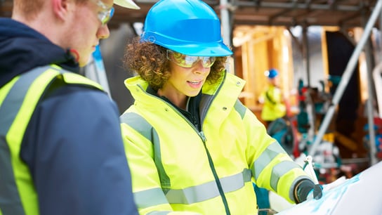 Women looking at plans on construction site 