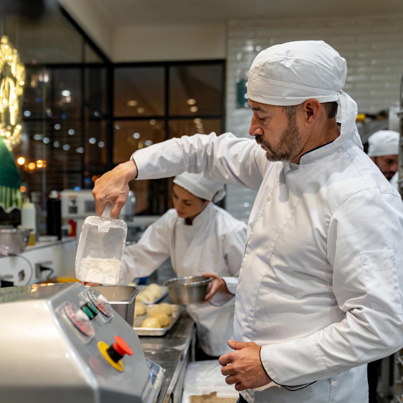 Food safety - Latin American baker making bread while working at a bakery