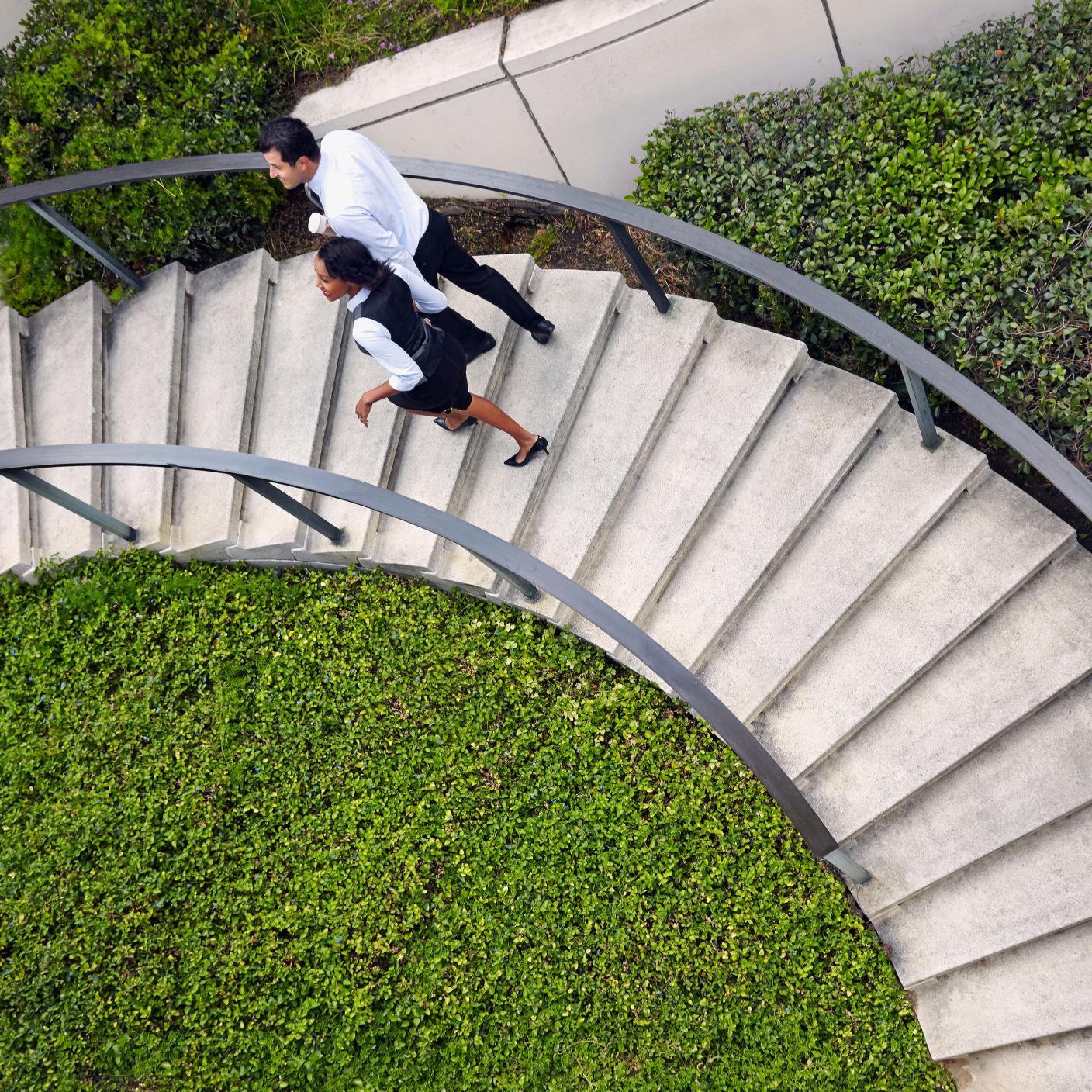 High angle view of business people ascending spiral stairway