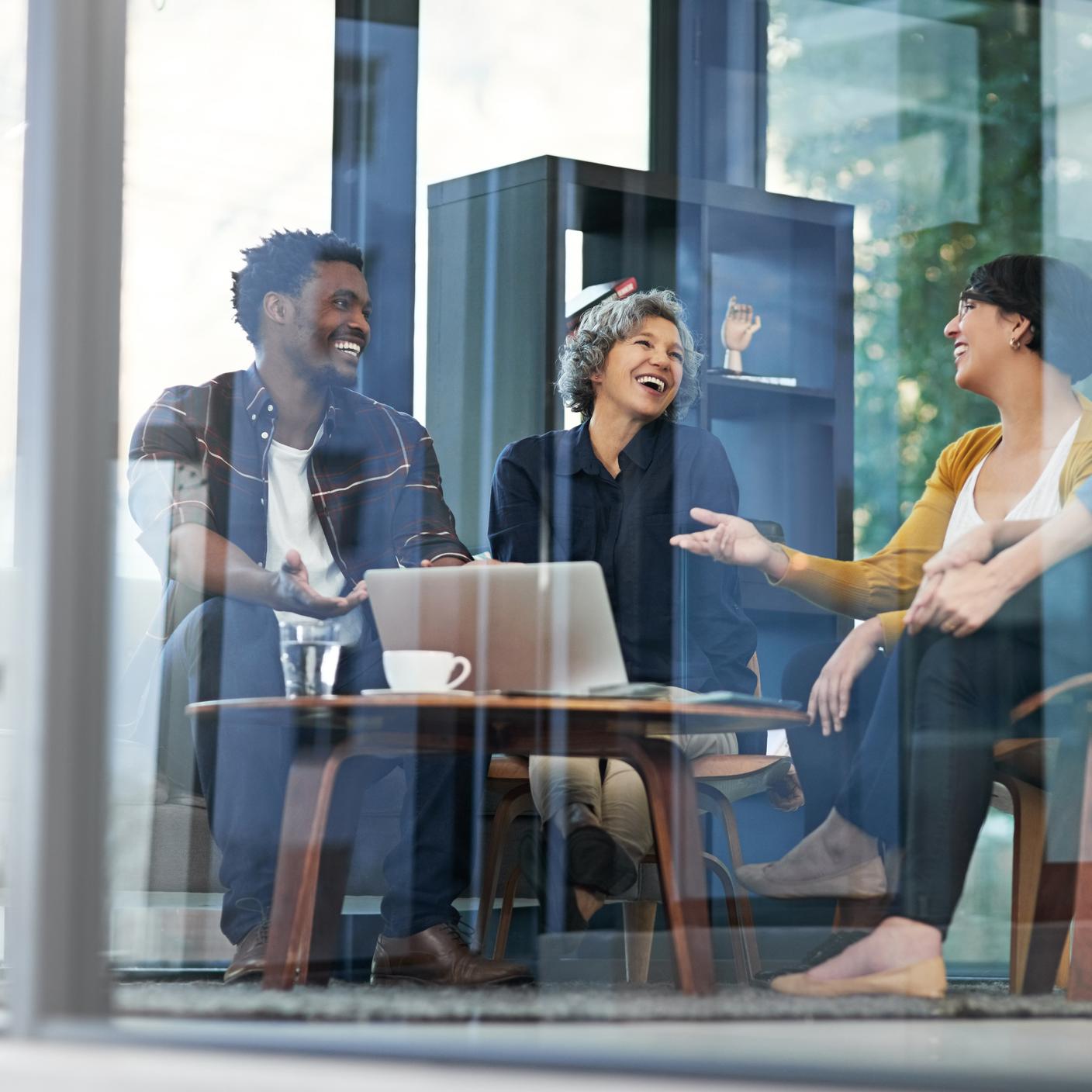 Internal management meeting between three smiling people