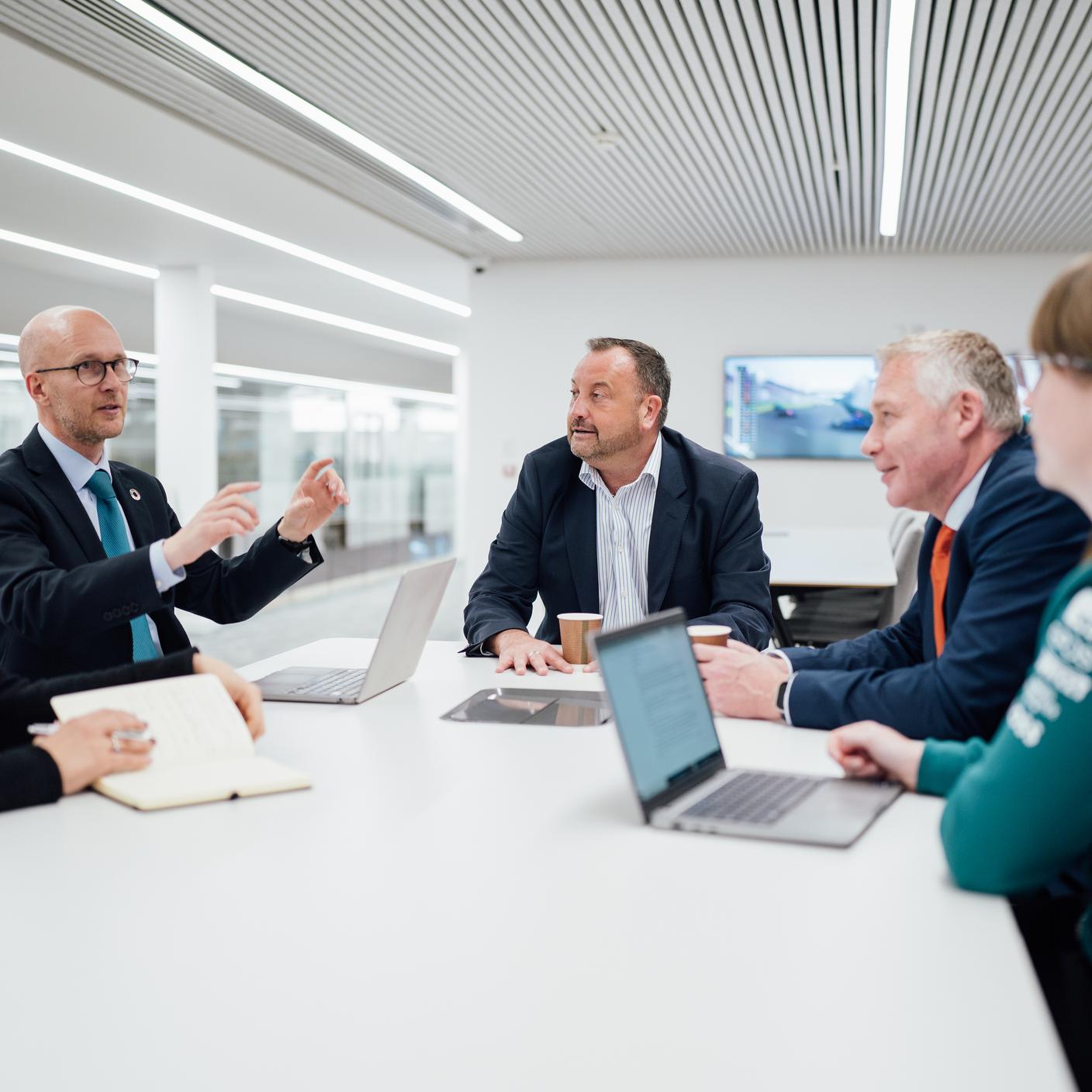 BSI- en Aston Martin-teams in vergadering in smart office