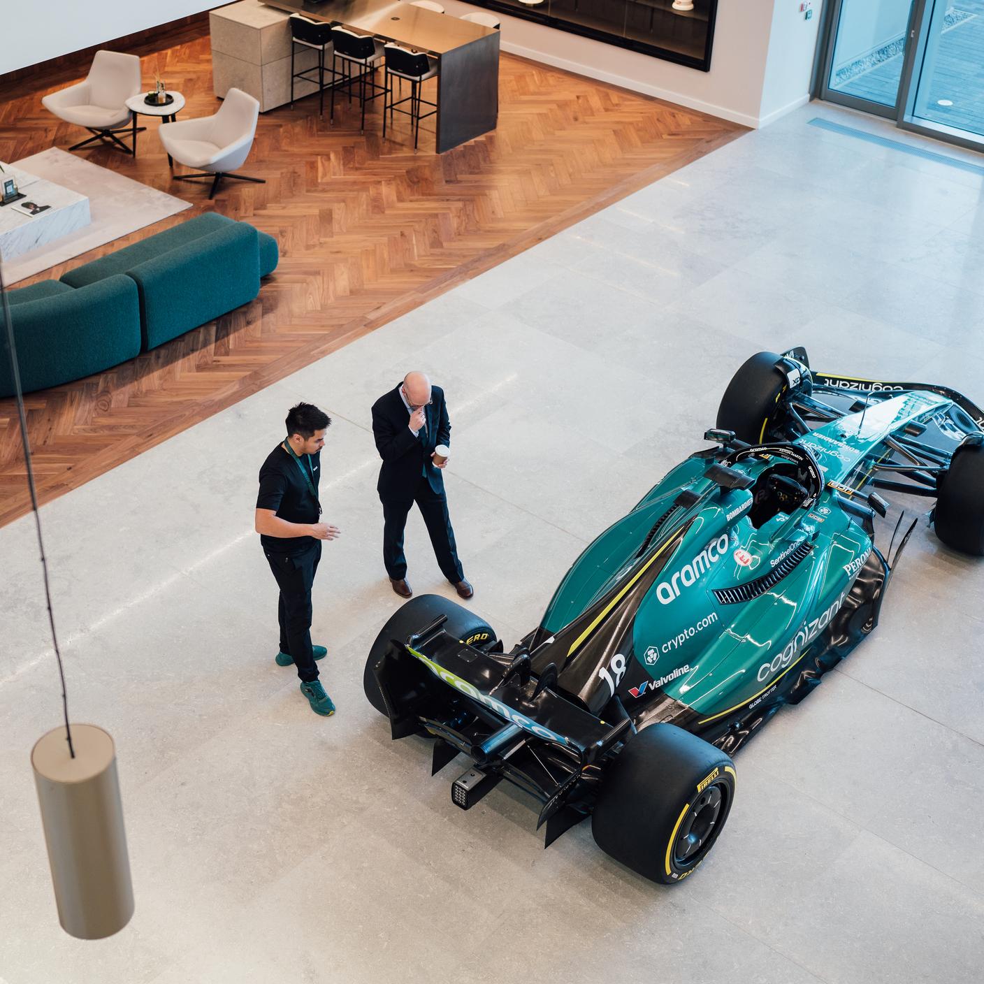 Bovenaanzicht van foyer Aston Martin-gebouw met Formule 1-racewagen