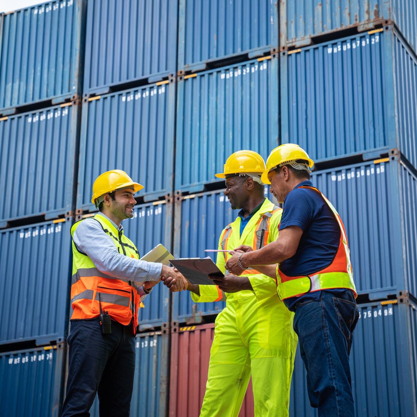 Male Industrial Engineer and Foreman control checking container at container yard warehouse.
