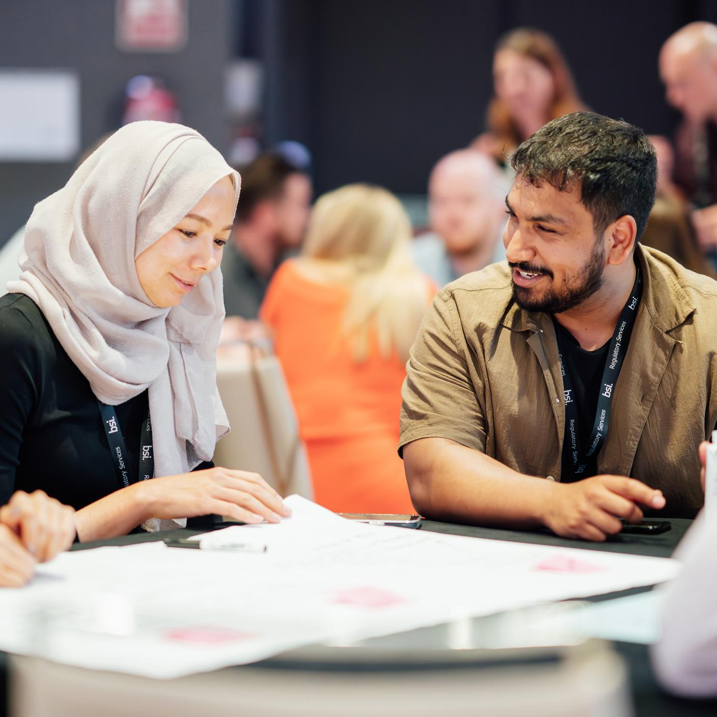 Consumer standards - man and women discussing work at table