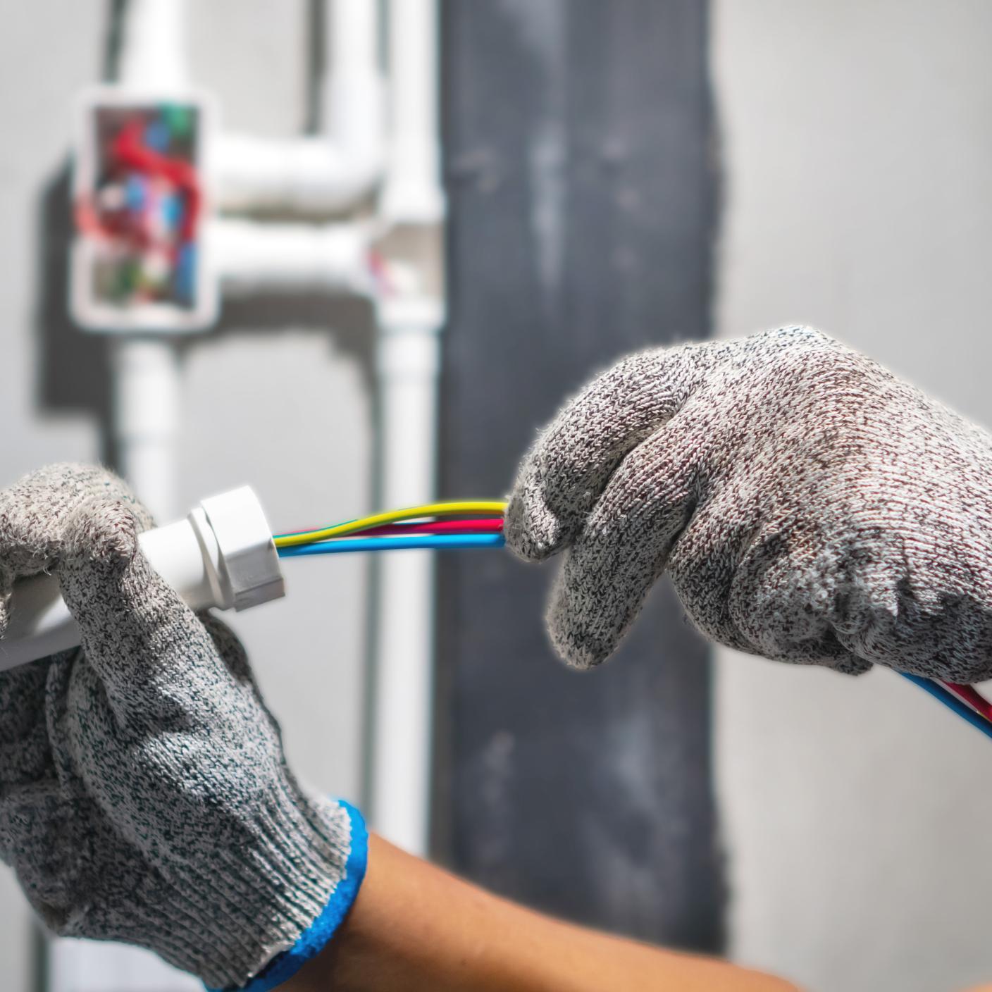 Electrician pulling wire into PVC Conduit.