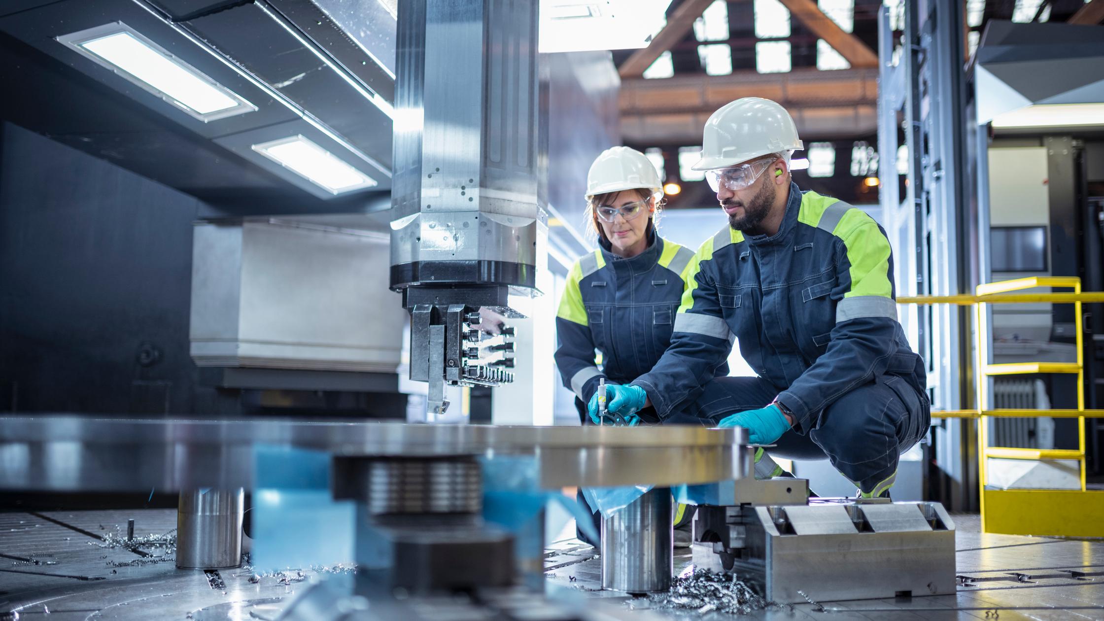 Male and female specialist lathe operators in steelworks