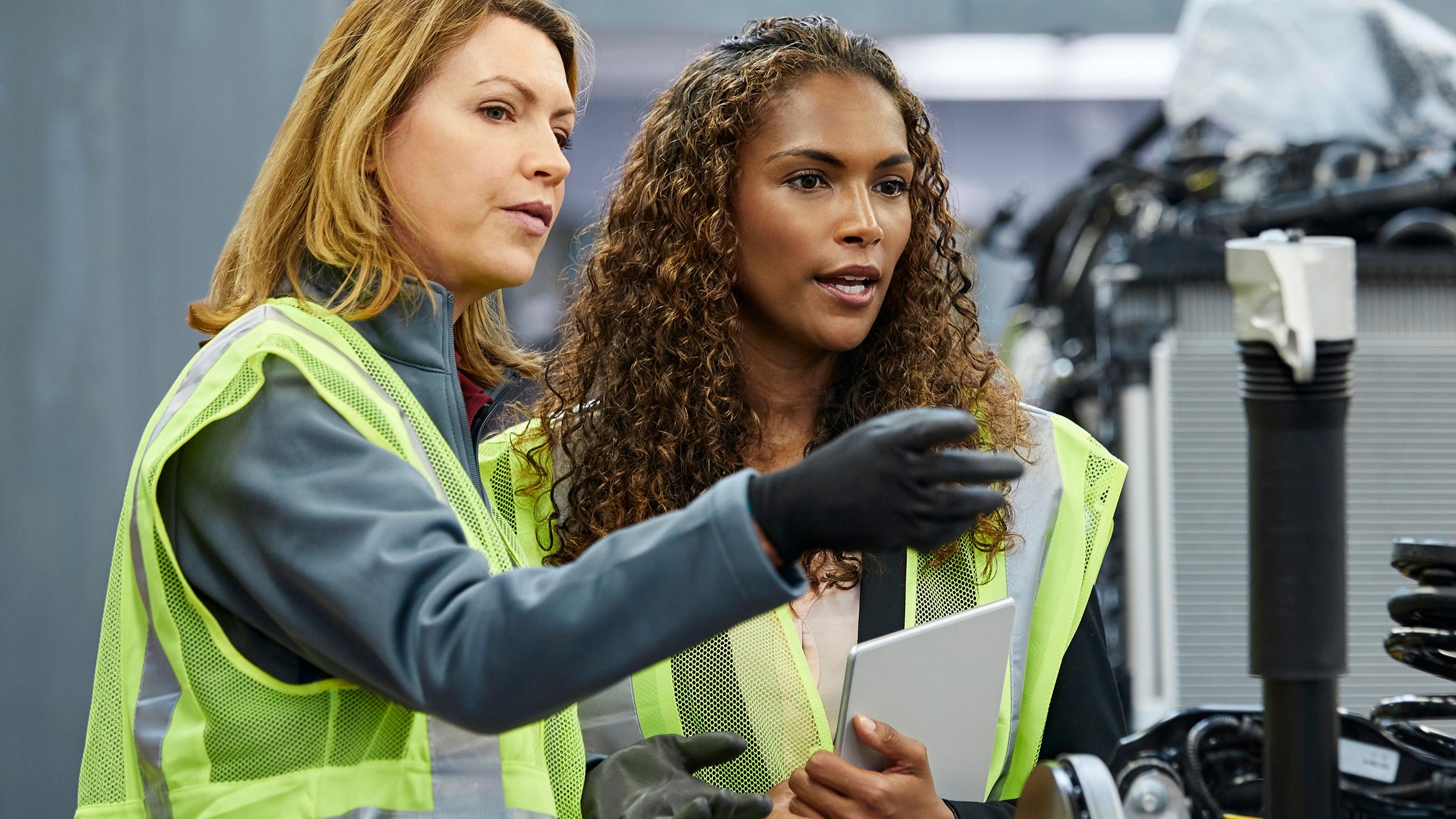 Engineers discussing over car chassis within automobile industry