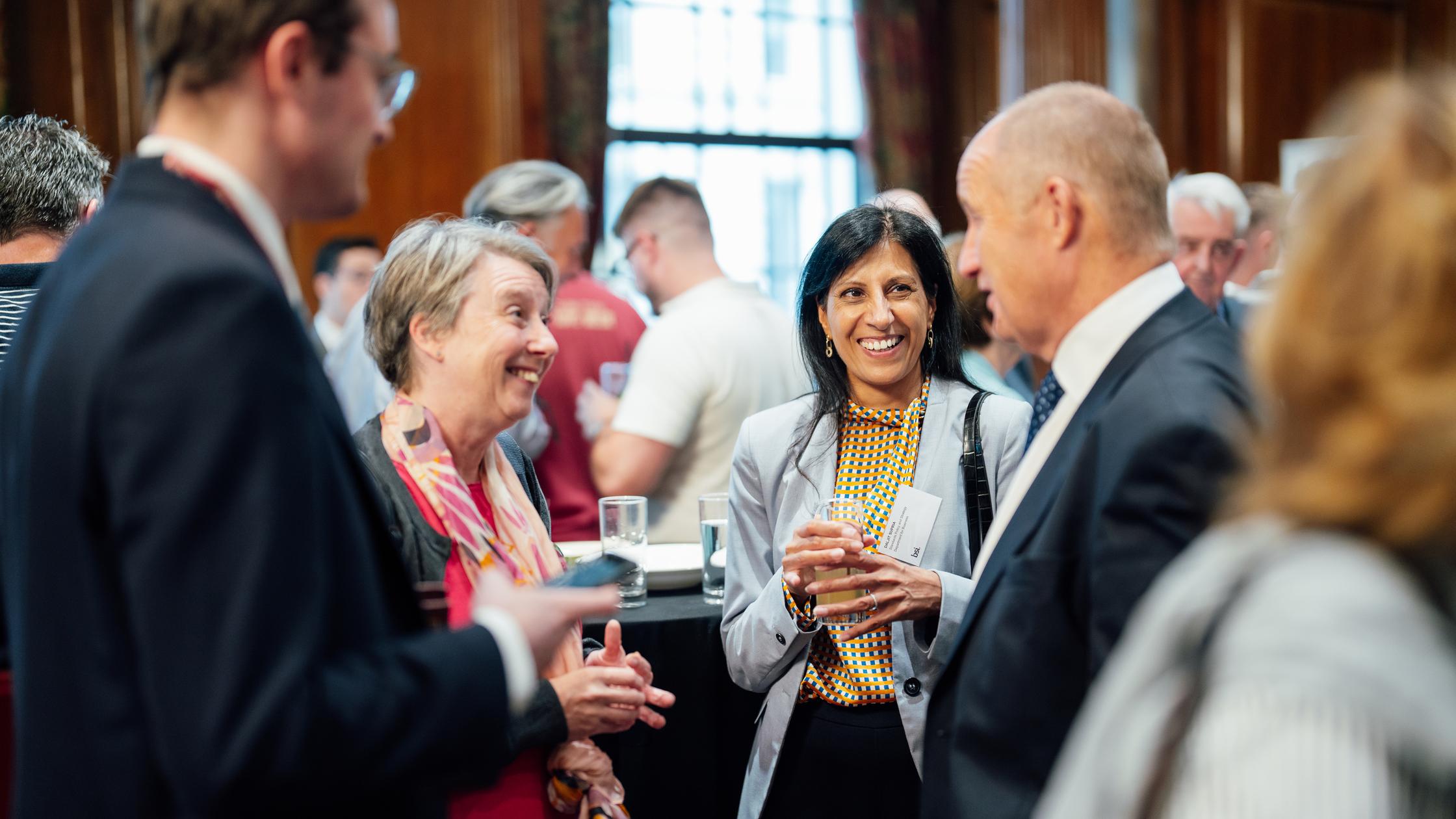 Duża grupa osób rozmawiających podczas standardowego spotkania w zatłoczonym pomieszczeniu