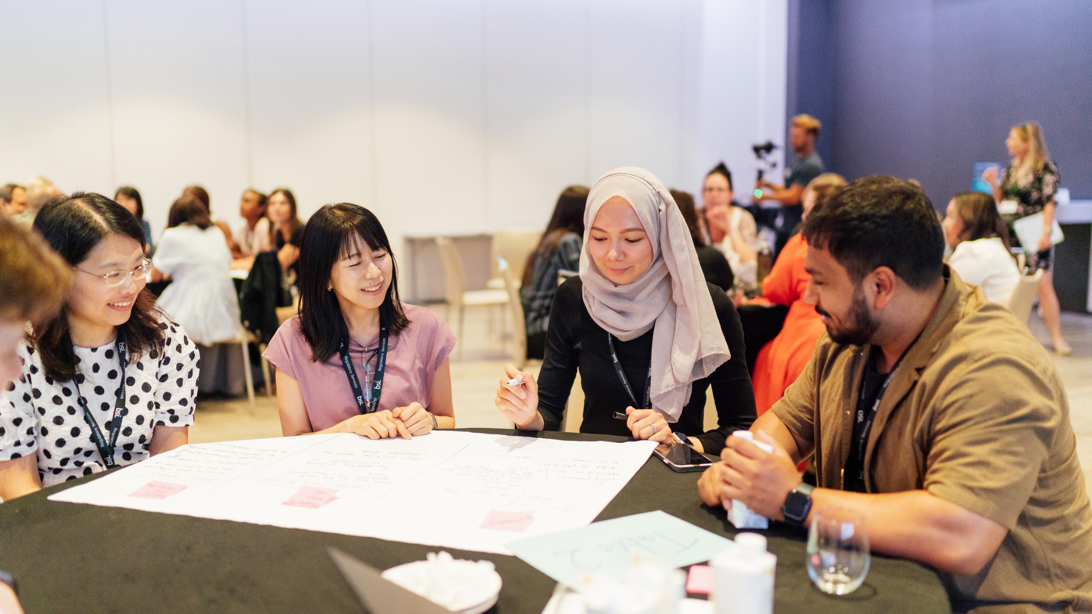 Mann und Frauen diskutieren an einem Tisch